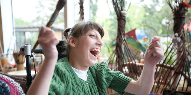 Girl in wheelchair laughing in the art room. Girl in wheelchair laughing in the art room.