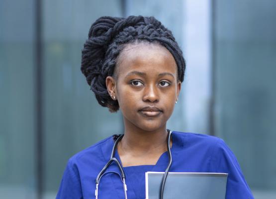 Medical student with black hair up in braids and stethoscope around neck