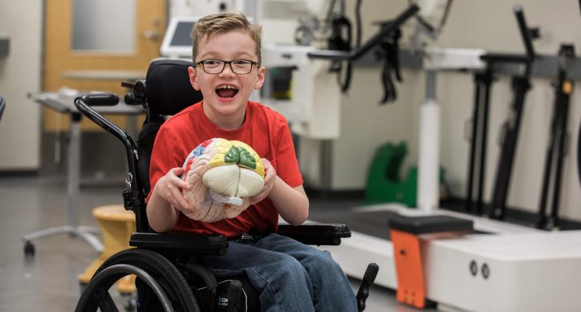 Client in a wheelchair playing with a brain toy