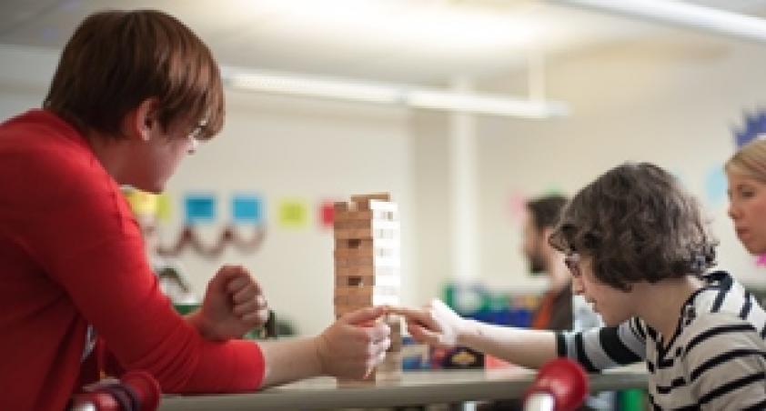 Woman and boy building a tower of wooden blocks