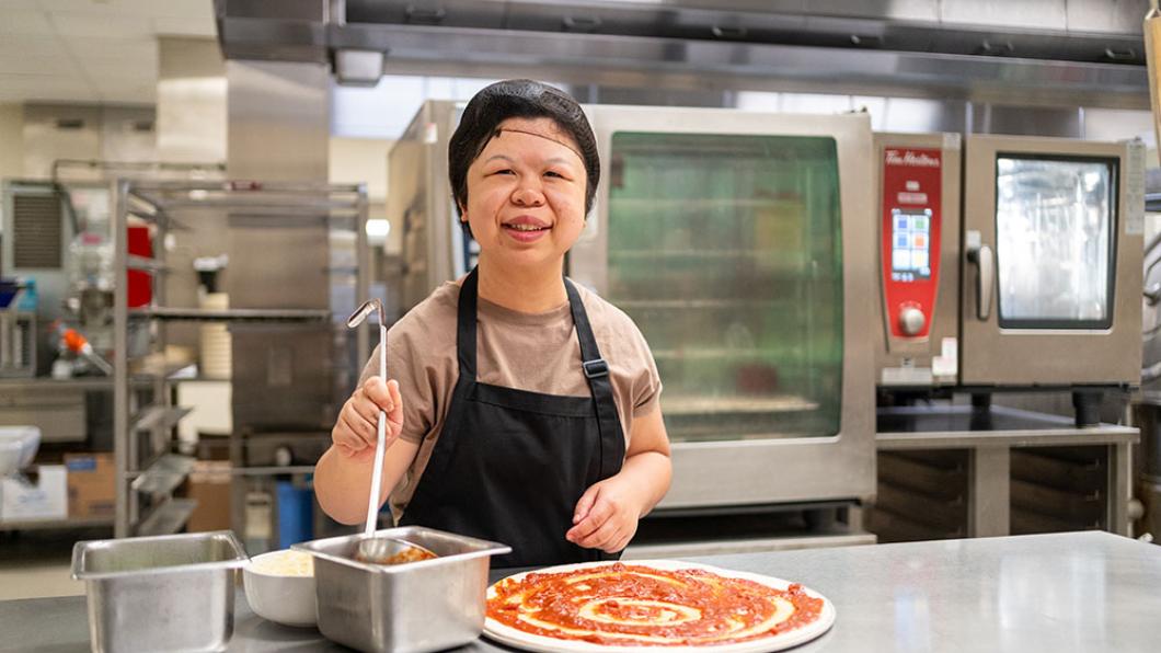 A kitchen staff making pizza