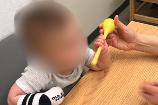 Place narrower thin toys for holding into infants hand