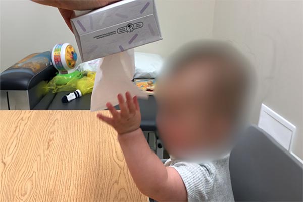 Using a box of tissues, or ribbons in an empty tissue box, hold the box upside down and encourage infant to pull out tissues/ribbons with palm facing infant.