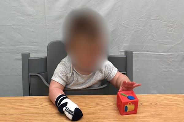 Play with a toy positioned close to the body on a tray/ table top. 