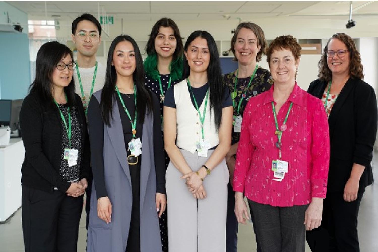 A group of people standing and smiling at the camera
