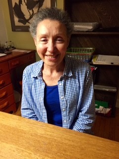 A family leader sits at a wood table, smiling.