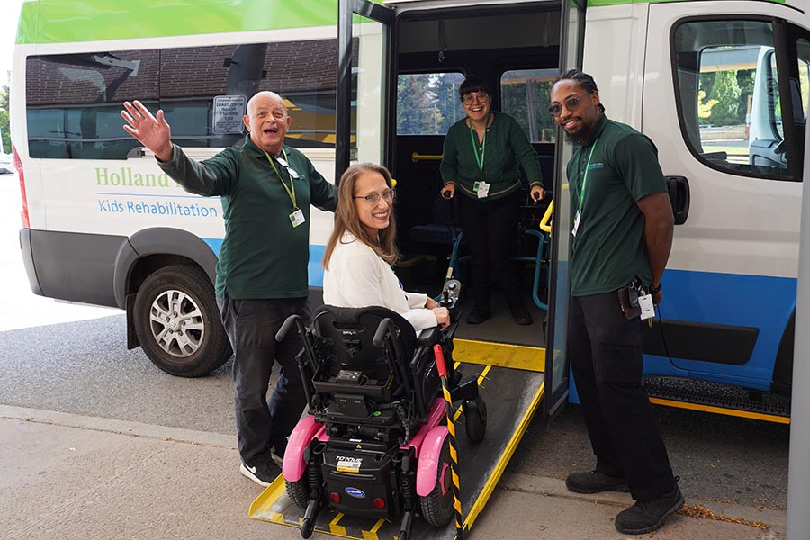 A lady with wheelchair riding on a bud from a ramp