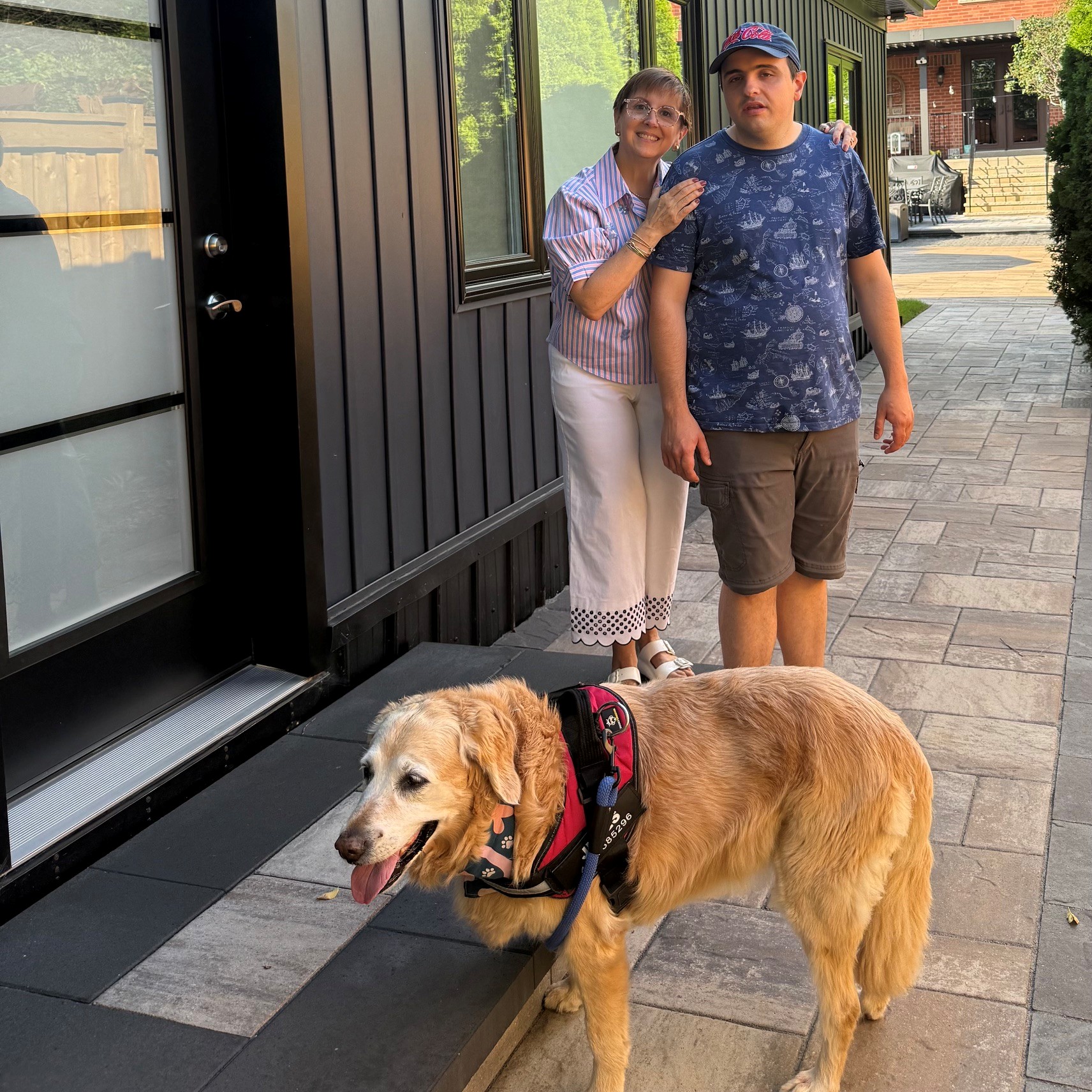 Woman and young man with golden retriever dog