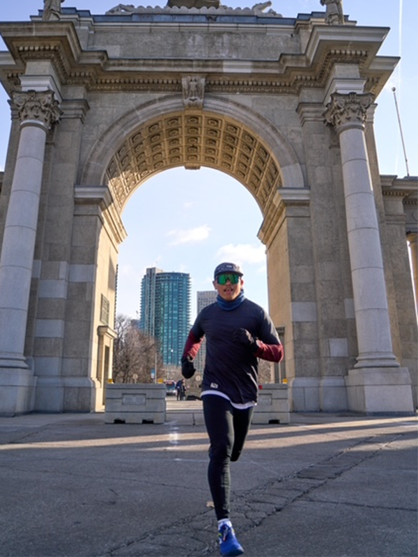 A man runs through a tall stone gate