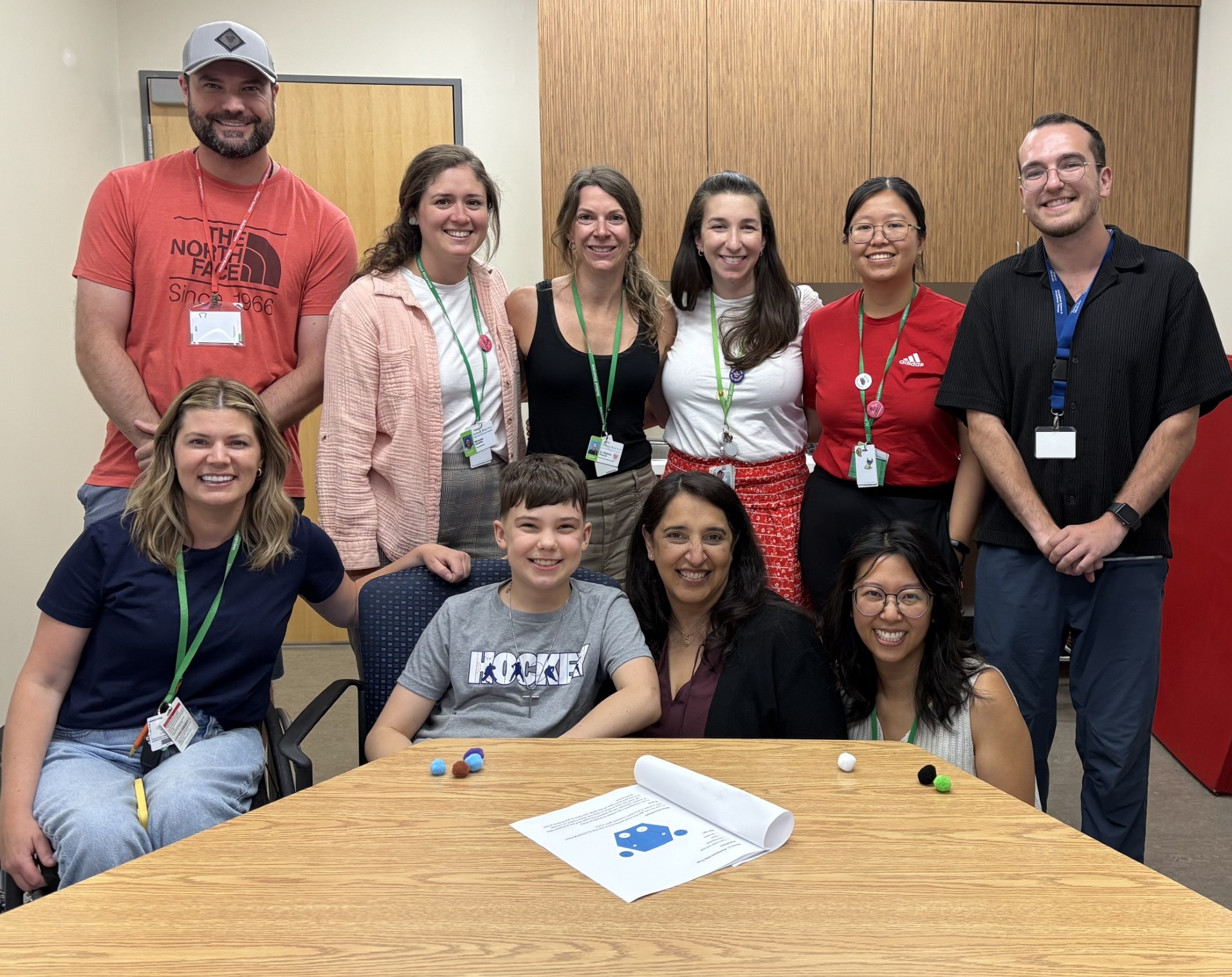 Boy in grey shirt at table surrounded by adults
