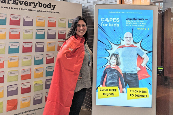 woman with cape standing in hospital's atrium
