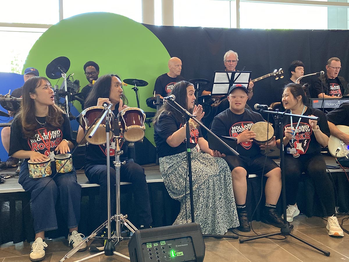 HB Rocks band members pose with volunteers, staff, and members of The Jam music hobbyist group.