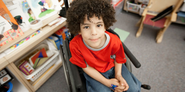 Little boy in wheelchair in the library.