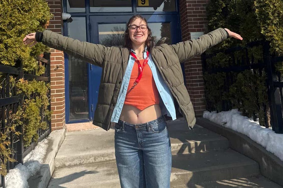 female volunteer standing with her arms outstretched