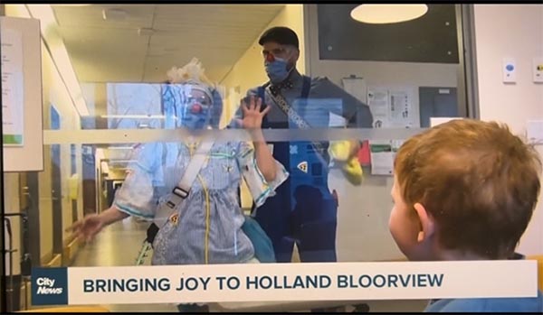 Two clowns looking into the window of a hospital ward