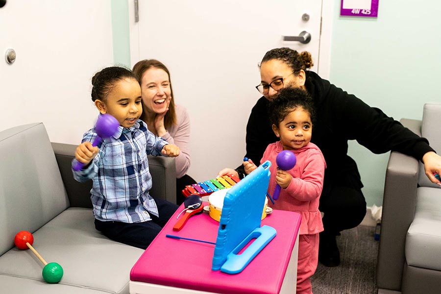 Dr. Elaine Biddiss looks on as family leader Alifa Khan watches her children play Bootle Band, one of a suite of rehabilitation-focused video games developed by the PEARL lab.