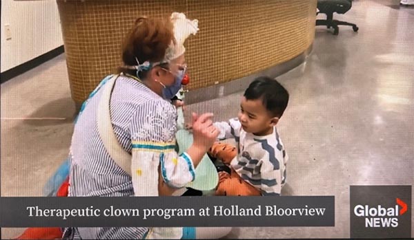 A clown playing with a young kid