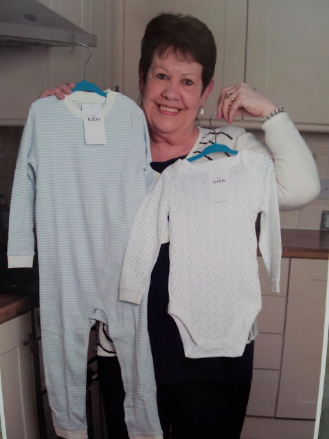 Rita holding up two bodysuits