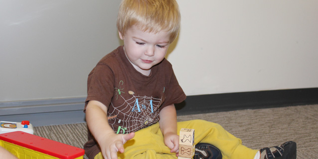Young boy playing with blocks.