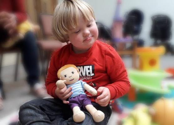 Little boy holding soft doll.