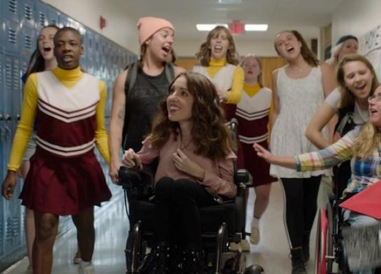 Girls in high school hallway including two in wheelchairs
