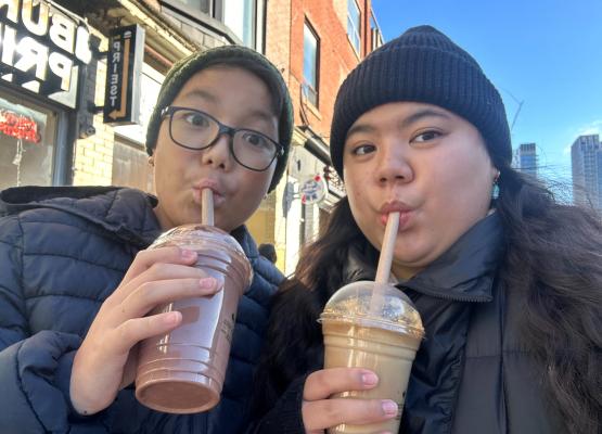 A woman and a boy slurp frothy drinks