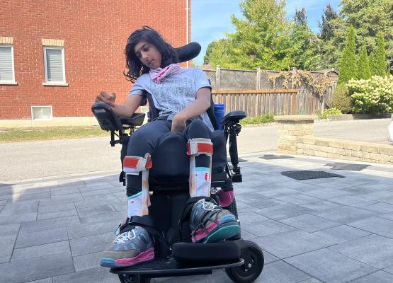 Teen girl uses power wheelchair outside