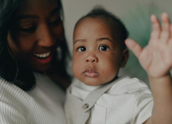 Baby waves in woman's arms