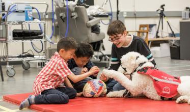 Clients playing with brain toy with guide dog