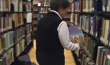 Putting a book back on the shelf in our Library