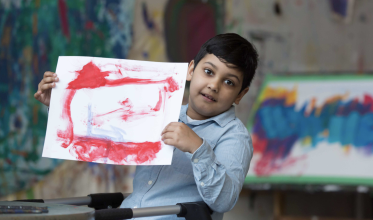 Boy holding up artwork 