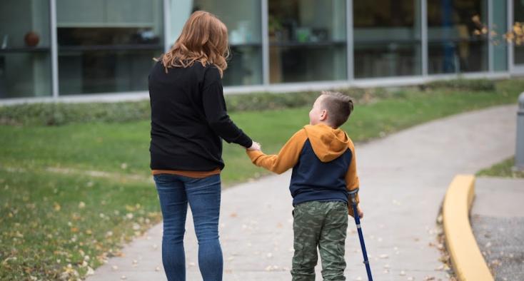 woman and young boy walking together on a path
