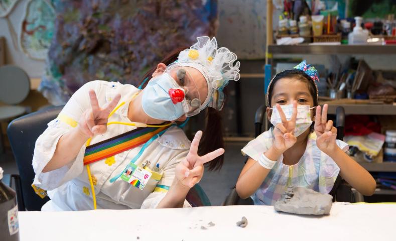 Nurse Flutter and client wearing masks at the art table
