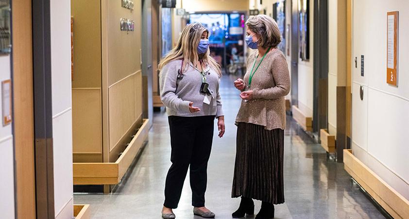 Two hospital staffs walking down the hallway