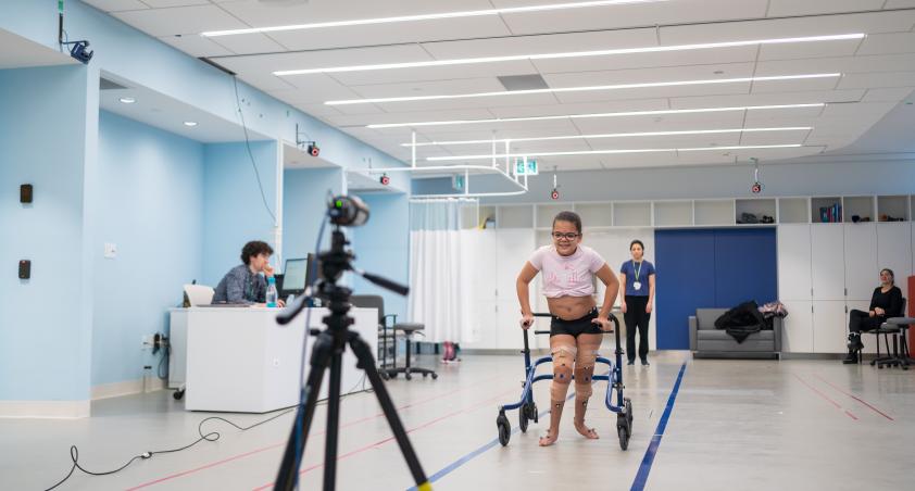 Child walking in blue lines in gait assessment room