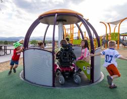 Image of children playing on accessible merry go round