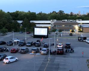 A wide view of the drive-in movie theatre in the parking lot. 
