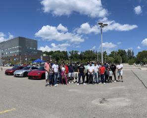 Group standing in front of exotic cars at Holland Bloorview.