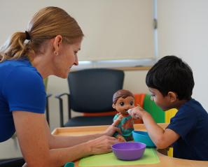 An adult is playing toys with a young child