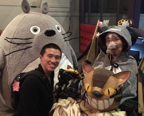 Man wearing Totoro costume beside another man with large plush character