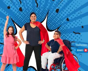 An adult, a kid to the left and another kid on wheelchair to the right. All with red cape at their back