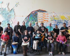 HB Rocks band members pose with volunteers, staff, and members of The Jam music hobbyist group.