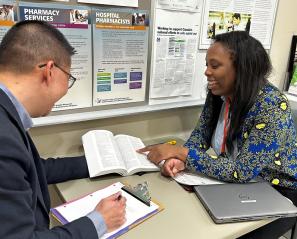 Nathan Ho, director of pharmacy and preceptor, chats with University of Toronto pharmacy student Olakemi Vilasa