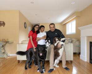 Boy in the middle of woman and man with three dogs