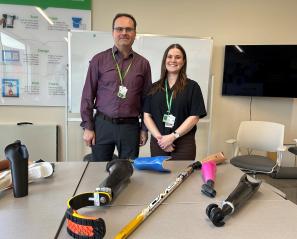 A man and a woman standing behind some tools for disabilities