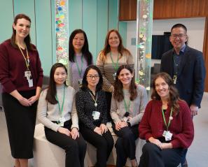 group of adults, some sitting and others standing, in a room with bubble towers in the background