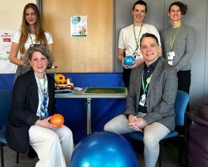group of adults, some sitting and others standing, in a room with bubble towers in the background