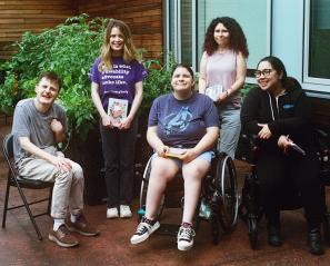 Five adults in an outdoor setting for a group photo
