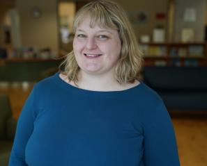 Woman with blonde hair and blue sweater in library