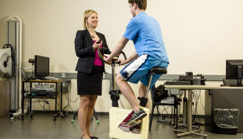 Scientist with a participant on an exercise bike